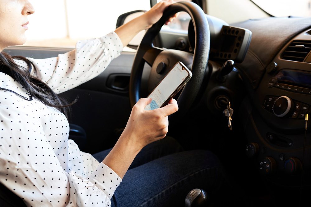 a woman texting and driving.