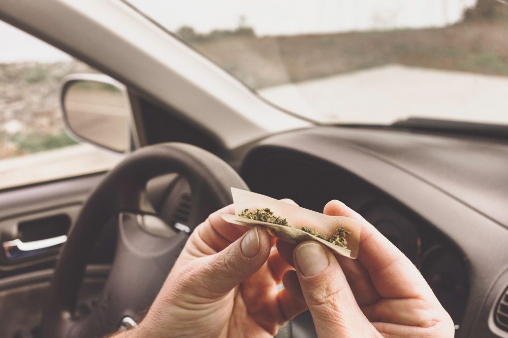 someone rolling a joint inside a car.