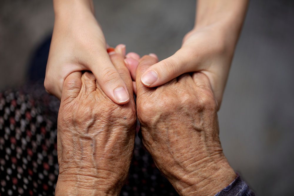 elderly holding hands.