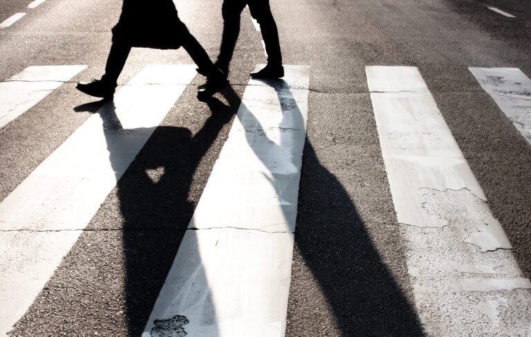 City,zebra,crossing,with,two,blurry,walking,pedestrians,making,long