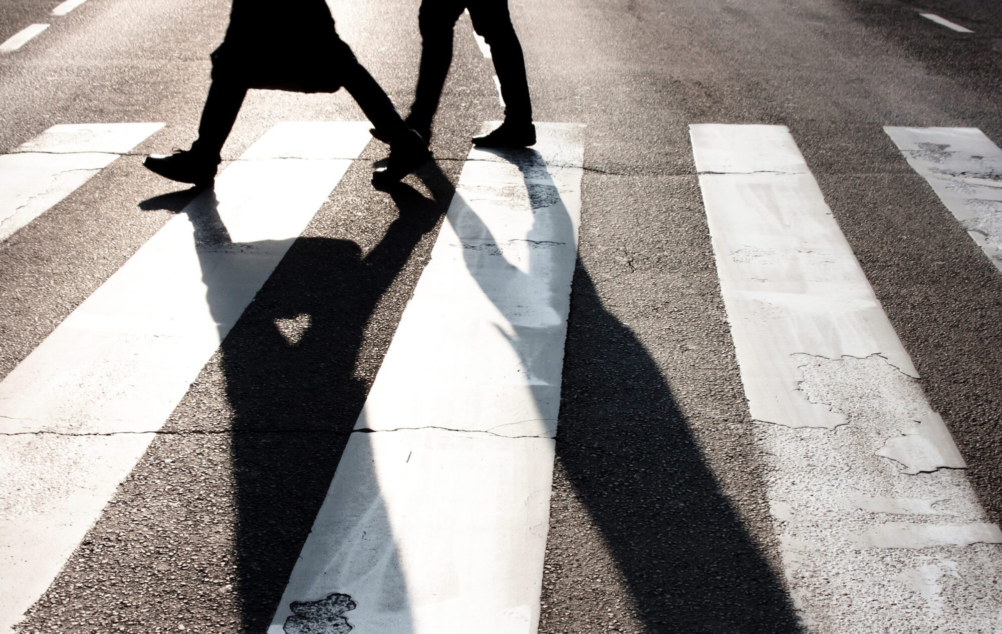City,zebra,crossing,with,two,blurry,walking,pedestrians,making,long